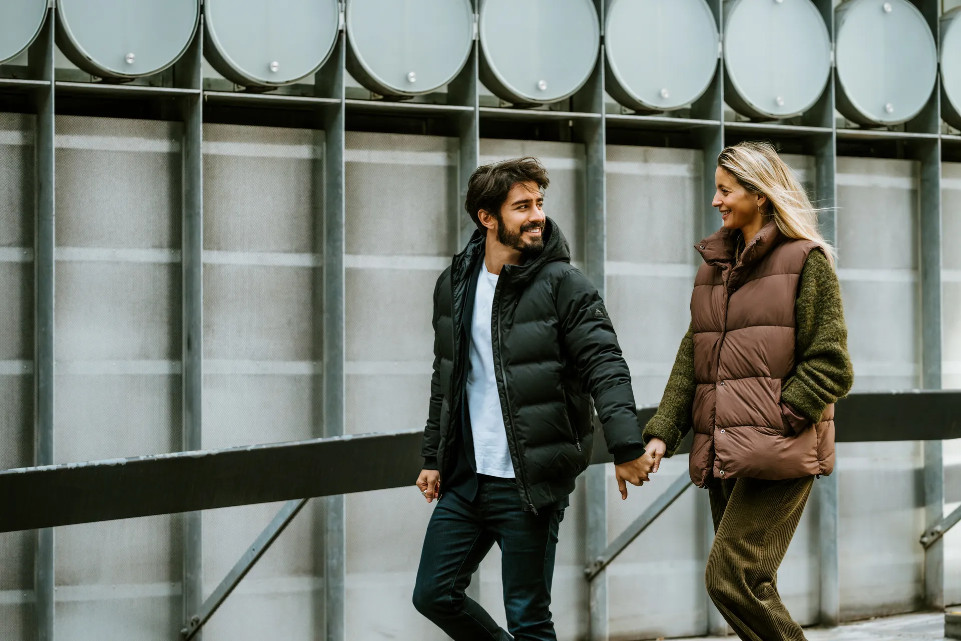 A couple walking hand in hand along a city street